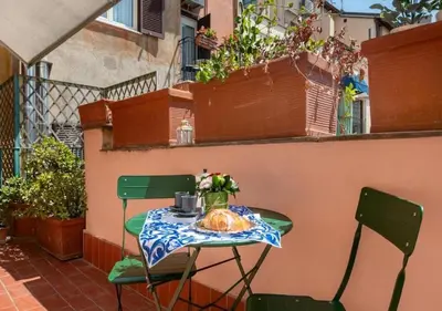 a table with a croissant and flowers on a balcony at Luxury in Rome Panoramic terrace Fontana di Trevi in Rome