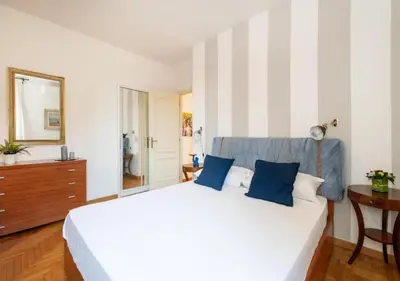 a bedroom with a large white bed with blue pillows at Luxury in Rome Panoramic terrace Fontana di Trevi in Rome