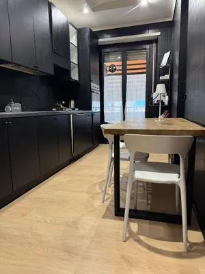 a kitchen with a table and white chairs in it at Marconi Suite & Charme in Rome
