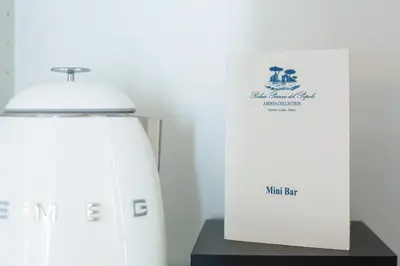 a white refrigerator next to a box on a table at Relais Piazza Del Popolo in Rome