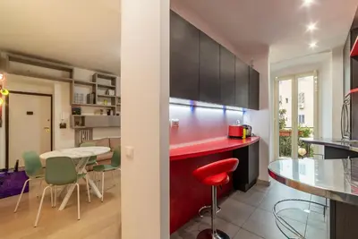 a kitchen with a red counter and a table and chairs at Leone IV - WelcomeToRhome in Rome