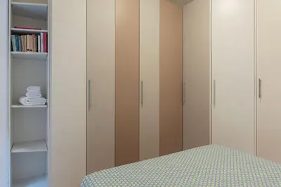 a bedroom with white and brown cabinets and a bed at Leone IV - WelcomeToRhome in Rome