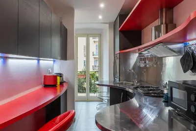 a kitchen with black cabinets and a red counter top at Leone IV - WelcomeToRhome in Rome