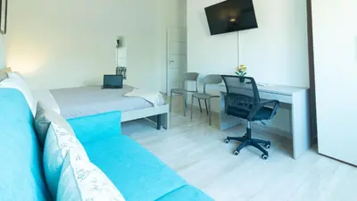 a room with a couch and a bed and a desk at Casa vacanza Appartamento Irnerio vicino la Metro in Rome