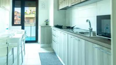 a white kitchen with a sink and a stove at Casa vacanza Appartamento Irnerio vicino la Metro in Rome