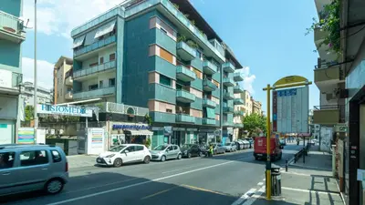a city street with cars parked in front of a building at Casa vacanza Appartamento Irnerio vicino la Metro in Rome