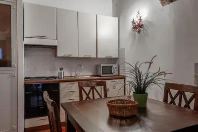 a kitchen with white cabinets and a wooden table at Appartamento Castel Sant'Angelo in Rome