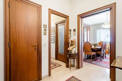 a hallway with a dining room with a table and a dog on a chair at The Pope's Room in Rome