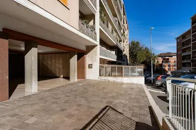 a building with a parking lot next to a parking garage at The Pope's Room in Rome