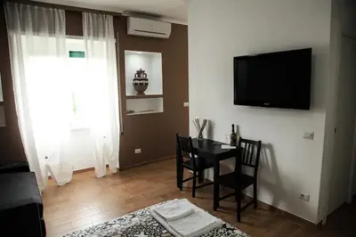 a living room with a table and a television on a wall at Sunset Home in Rome