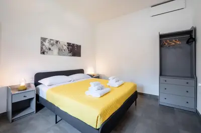 a bedroom with a yellow bed and a flat screen tv at Angelina Domus Saint Peter's in Rome