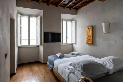 a bedroom with a large bed and two windows at Roma apartments in Rome