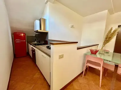 a small kitchen with a table and a red refrigerator at Linda Charme in Rome