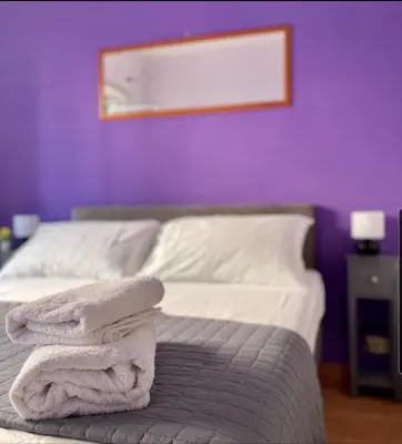 a bedroom with a bed with a purple wall at K-Vatican Apartment in Rome