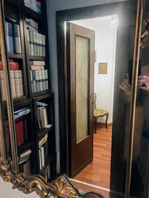 a mirror reflection of a door in a room at 5 metro stop colosseum in Rome
