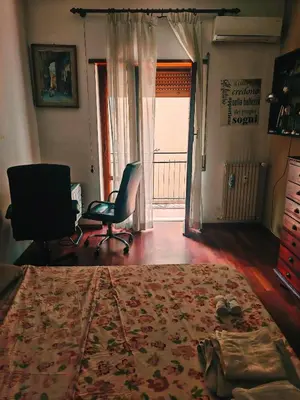 a bedroom with a bed and a chair and a window at 5 metro stop colosseum in Rome