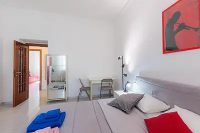 a bedroom with a large white bed with a painting on the wall at 10 Min Colosseum, PreNestInHome - Renovated 2024 Apartment, P igneto , Self Check-in h24 in Rome