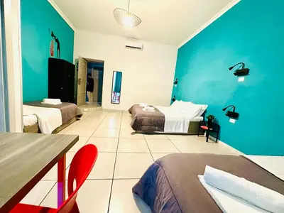 a bedroom with two beds and a blue wall at Jupiter Home in Rome