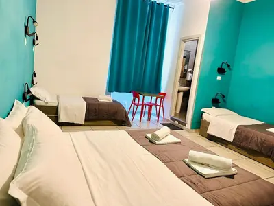 a room with three beds and a table and a chair at Jupiter Home in Rome