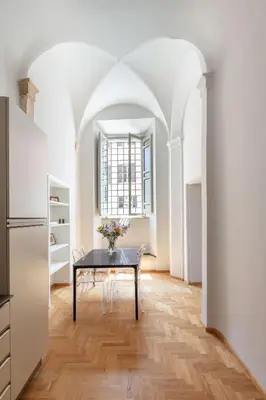 a dining room with a table and a kitchen at Casa Paolina, Burghesius homes in Rome