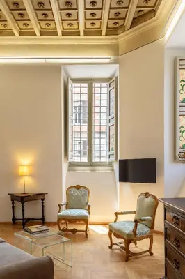 a living room with two chairs and a table at Casa Paolina, Burghesius homes in Rome