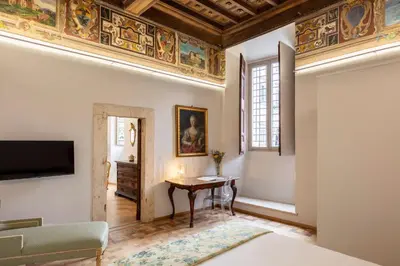 a living room with a table and a ceiling with paintings at Casa Paolina, Burghesius homes in Rome