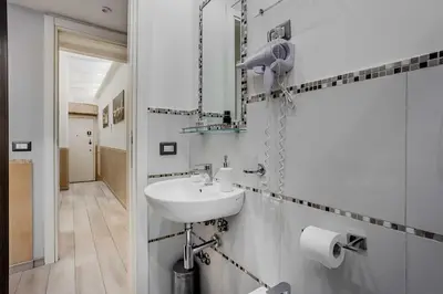 a white bathroom with a sink and a mirror at Vatican Sweet Dreams Apartment in Rome
