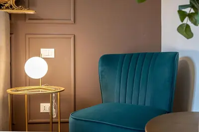 a blue chair next to a table with a lamp at Exclusive View Rome I Residenza di Prestigio I 5 min metro Colosseo in Rome