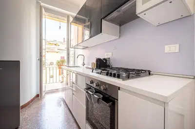 a kitchen with white counters and a stove top oven at Exclusive View Rome I Residenza di Prestigio I 5 min metro Colosseo in Rome
