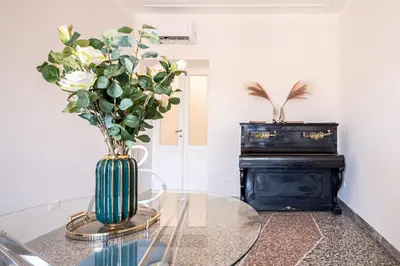 a glass table with a vase with flowers on it at Exclusive View Rome I Residenza di Prestigio I 5 min metro Colosseo in Rome