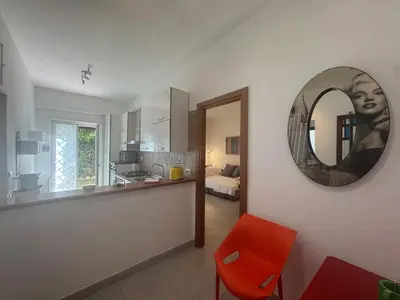 a kitchen with a red chair and a mirror at Urban Oasis with Garden in Rome