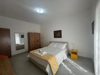 a bedroom with a large bed with a yellow blanket at Urban Oasis with Garden in Rome