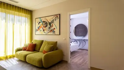 a living room with a green couch and a window at Soggiorno Chic , 2 Camere Vicino Colosseo e Metro in Rome