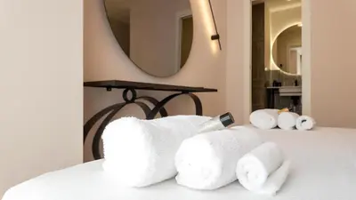 a pile of towels sitting on top of a bed at Soggiorno Chic , 2 Camere Vicino Colosseo e Metro in Rome