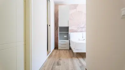 a bedroom with a white bed and a mirror at Soggiorno Chic , 2 Camere Vicino Colosseo e Metro in Rome