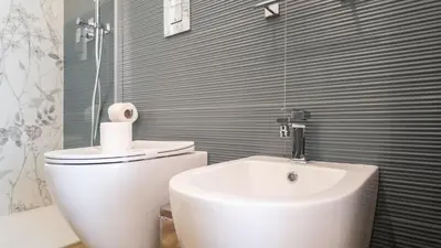 a bathroom with a white toilet and a sink at Soggiorno Chic , 2 Camere Vicino Colosseo e Metro in Rome