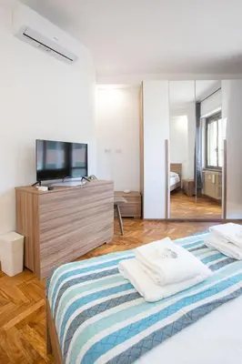 a bedroom with a bed and a large mirror at VI Domus - Vatican Museum Guest House - Roma in Rome