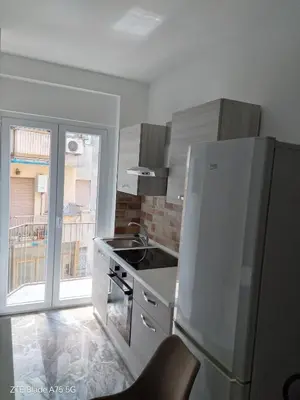 a white kitchen with a refrigerator and a sink at VI Domus - Vatican Museum Guest House - Roma in Rome
