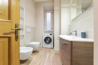 a bathroom with a washing machine and a washer and dryer at Casa Aurora - WelcomeToRhome in Rome