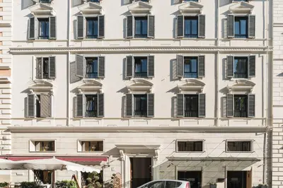 a white building with windows and a car parked in front at Casa Aurora - WelcomeToRhome in Rome