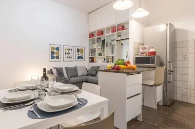 a kitchen and living room with a table with plates and wine glasses at Casa Aurora - WelcomeToRhome in Rome
