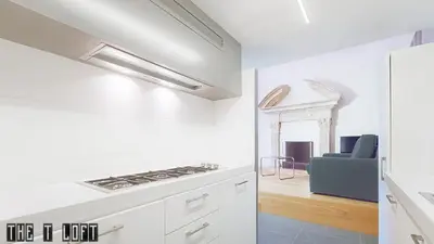 a kitchen with white cabinets and a stove top oven at Trastevere Loft in Rome