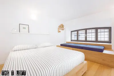 a white bedroom with a bed and a window at Trastevere Loft in Rome
