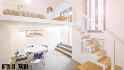 a kitchen and dining room with a staircase and a table at Trastevere Loft in Rome