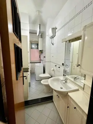 a white bathroom with a sink and a toilet at San Giovanni Apartment in Rome