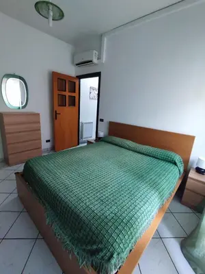 a bedroom with a bed with a green comforter at San Giovanni Apartment in Rome