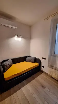a bed in a room with a yellow blanket at Domus Albalonga in Rome