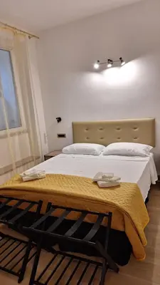 a bedroom with a large bed with white sheets at Domus Albalonga in Rome