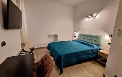 a bedroom with a blue bed and a television at Domus Albalonga in Rome
