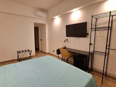 a bedroom with a bed and a desk and a television at Domus Albalonga in Rome